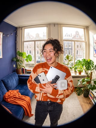 Persoon multitaskt met telefoon, laptop en tv thuis